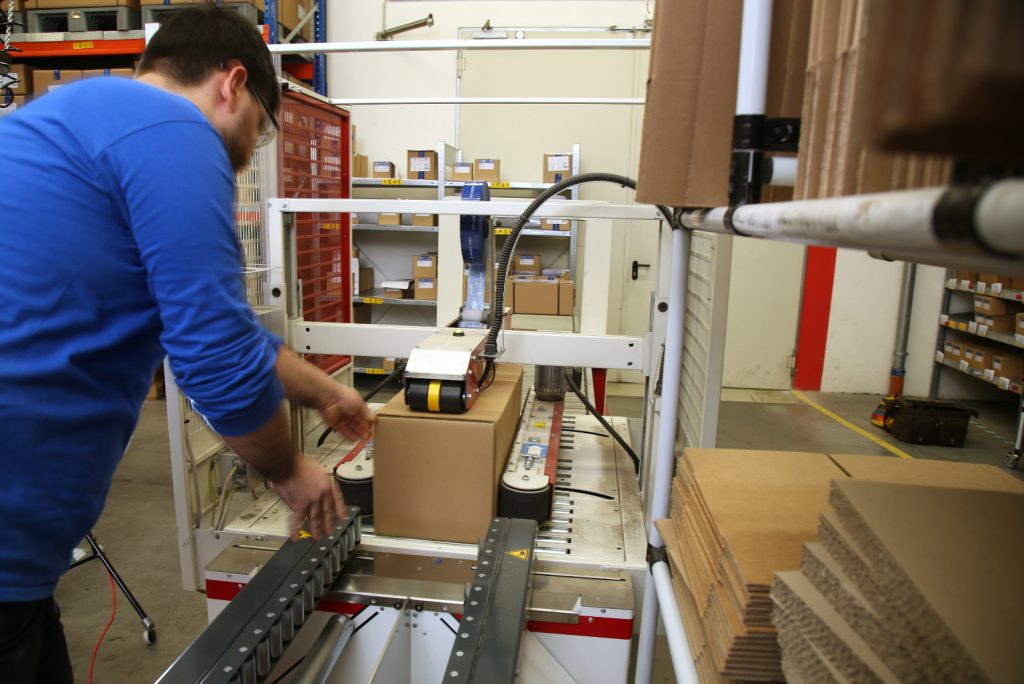 Je nach Anwendung und internen Prozessstrukturen werden die Trays in einen vorbereiteten Karton im Bodenklappenfalter gesetzt.