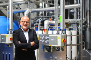 HERMA Geschäftsführer Dr. Thomas Baumgärtner vor der neuen dezentralen Dampferzeugungsanlage. (Bild: HERMA GmbH )