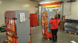 Eine Spar-Mitarbeiterin kommissioniert einen Roll-Safe-Container in einem österreichischen Spar-Lager. (Bild:Press’n’Relations und SPAR)