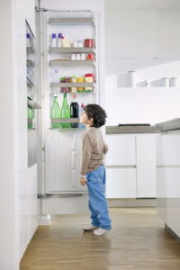 Kind vor Kühlschrank