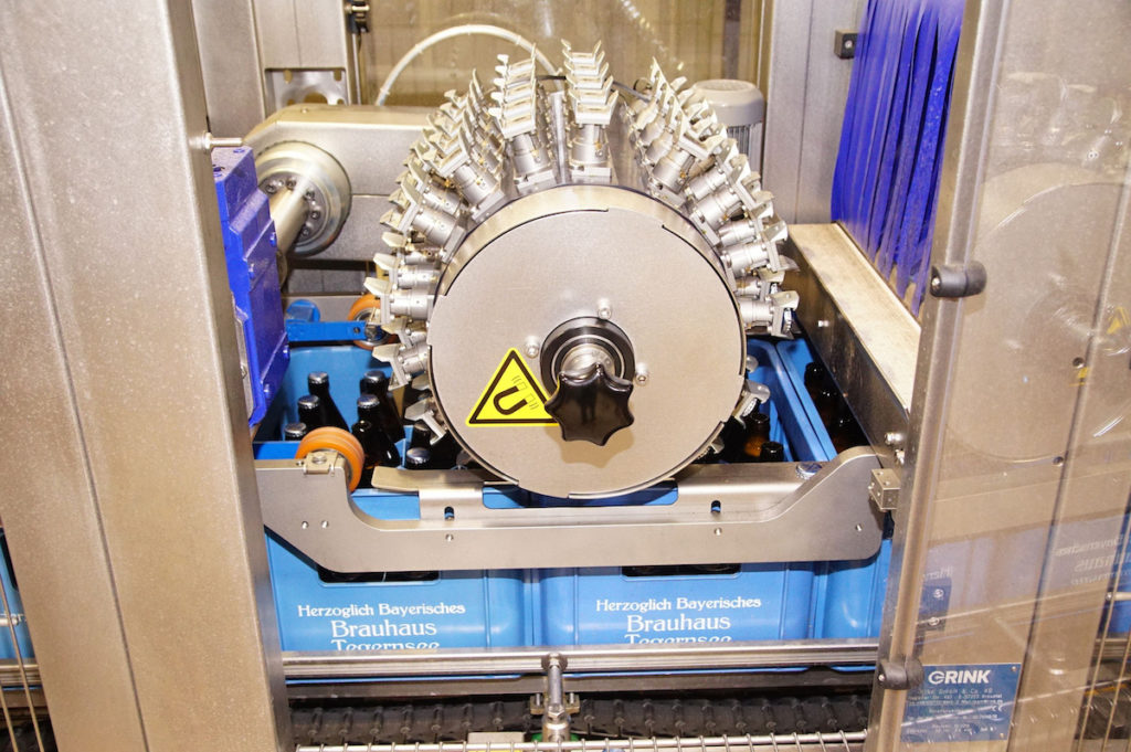 Beim Rotationsentkorker RK 940 entfernt eine sich drehende Walze die Verschlüsse mündungsschonend nach dem Flaschenöffnerprinzip. (Bild: broesele)