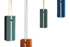 Mit einem Band, das die Flasche durch eine spezielle Fädelung an zwei Stellen hält, kann die Soapbottle sicher in der Dusche aufgehängt werden. (Bild: Jonna Breitenhuber)