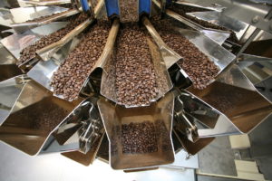 Die Kaffeebohnen gelangen durch einen Trichter auf die Mehrkopfwaage und werden über einzeln ansteuerbare Radialrinnen gleichmäßig auf die Vorschalen der Waage verteilt. (Bild: Ishida)