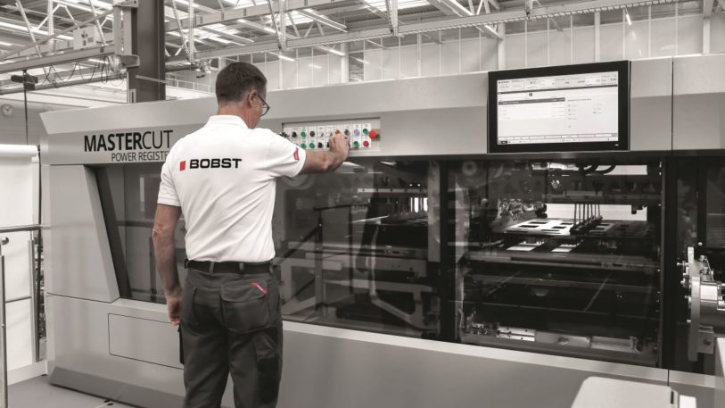 Bediener an Maschine von Bobst kontrolliert den Stanzprozess