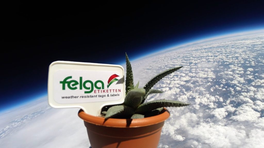 Kunststoffetikett von Felga und Blumentopf in der Stratosphäre