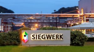Beleuchtetes Firmenlogo Siegwerk vor Gebaeude