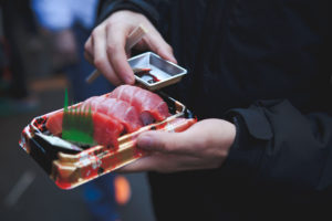 Sushi To-go-Verpackung in den Händen eines Mannes