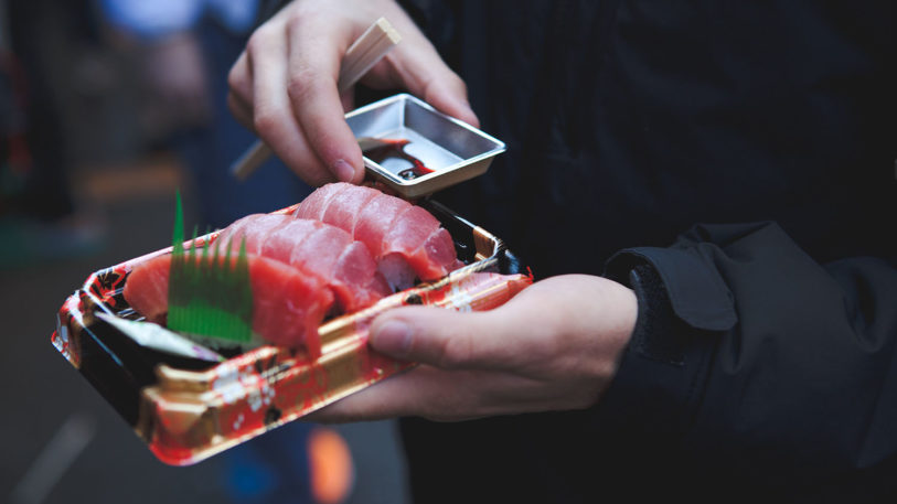 Sushi To-go-Verpackung in den Händen eines Mannes