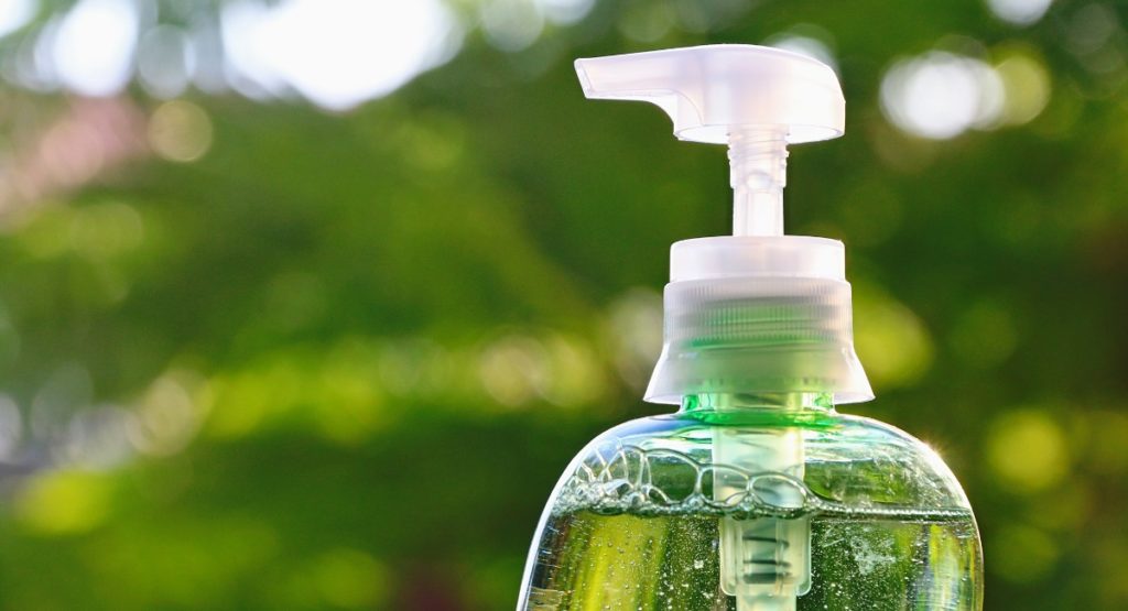 Reinigerflasche vor grünem Hintergrund Verbraucherzentrals NRW