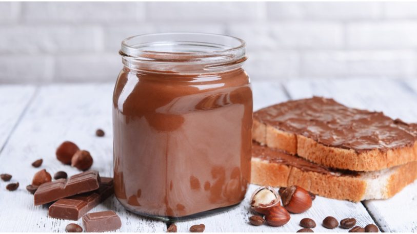 Nutella-Glas mit Brot und Schokolade und Nüssen