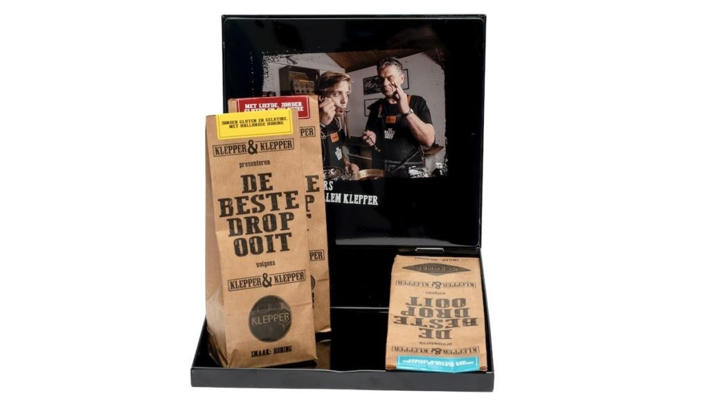 Geöffnete Blechdose mit drei Lakritzverpackungen