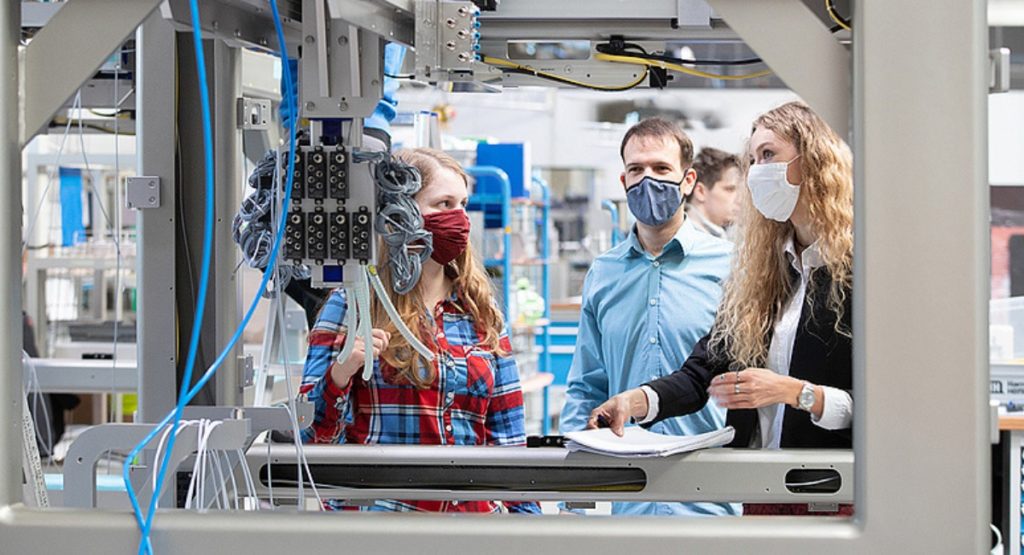 Menschen vor Anlage zur Verpackung von Corona-Impfstoff