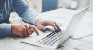 Mann vor aufgeklapptem Laptop