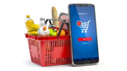 Einkaufkorb mit Waren und Smartphone