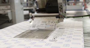 Die großen Design-Etiketten mit Informationen zum Produkt und Prüfsiegeln appliziert ein Etikettenspender Alpha HSM.