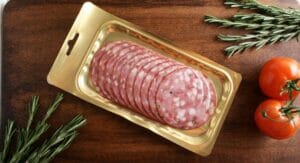Eine PVDC-haltige Wurstverpackung liegt auf einem Holzbrett