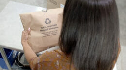 Eine Person hält die neue Verpackung von Amazon Fresh