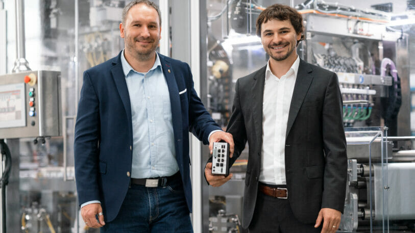 Picture of two men standing in front of machines.