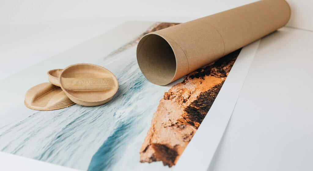 Eine Papierhülse und der dazugehörige Papierdeckel liegen auf einem Bild auf einem Tisch.