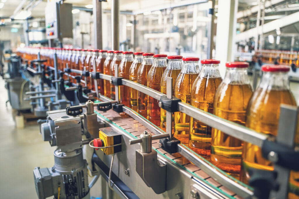 Picture of a filling line with filled glass bottles.