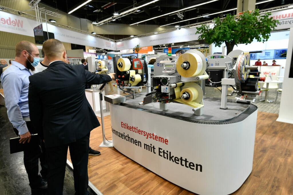 Bild von Personen auf einer Messe vor einem Messestand