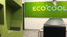 Bild von einem Raum mit einer grünen Wand, einem Tisch mit Stühlen und dem Logo der Ecocool GmbH.
