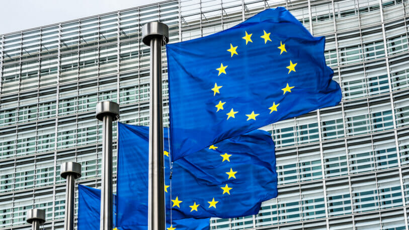 Bild von einem Gebäude, vor dem Flaggen der EU hängen.