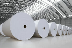 Image of big white paper rolls in a storage hall.