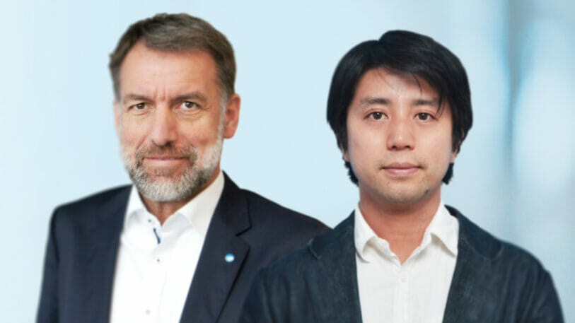 Bild von zwei Männern im Anzug vor einem blauen Hintergrund