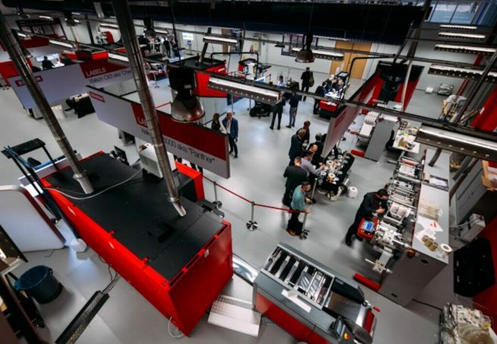 Bild einer Halle mit Menschen und Maschinen