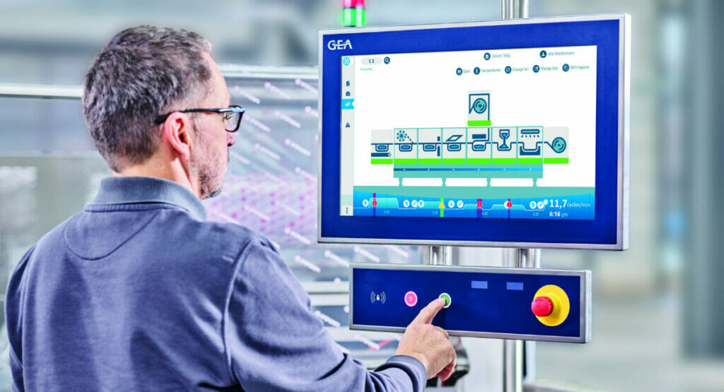 Bild von einem Mann, der an einer Maschine mit einem TouchScreen Bildschirm steht
