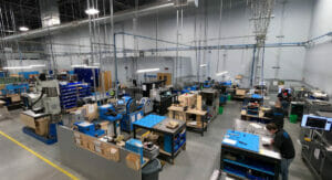 Bild von einer Produktionshalle, in der Menschen an Maschinen arbeiten