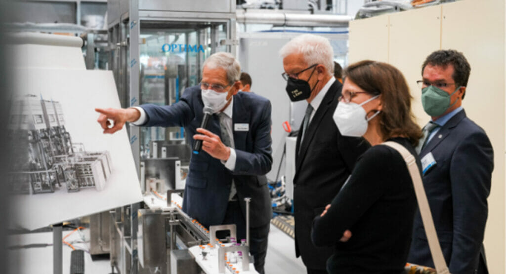 Image of people standing at a machine and receiving an explanation.