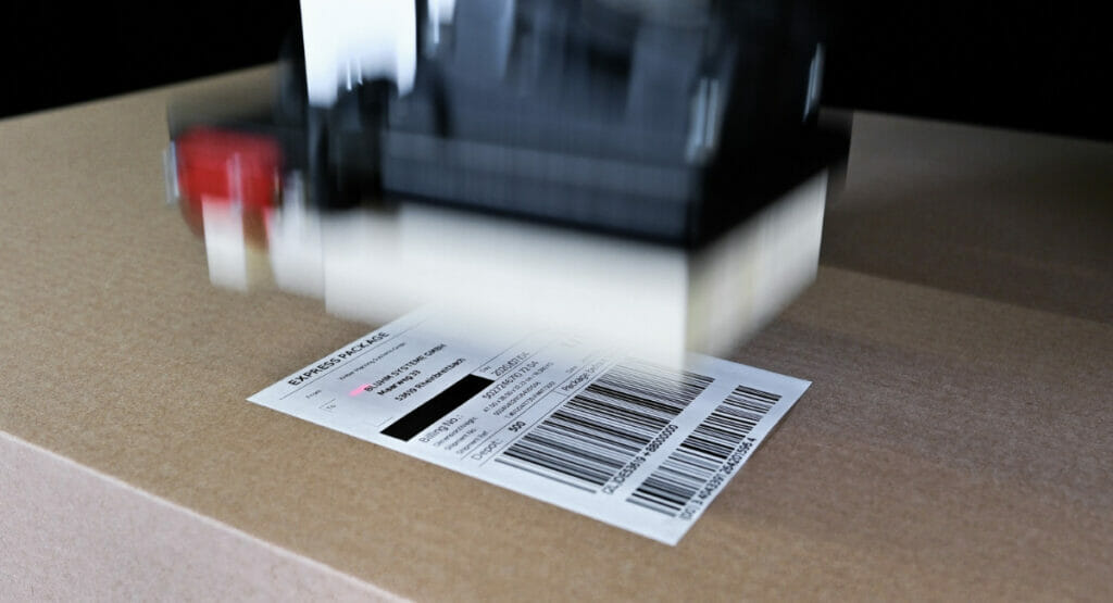 Bild von einem Karton, der von einer Maschine etikettiert wird.