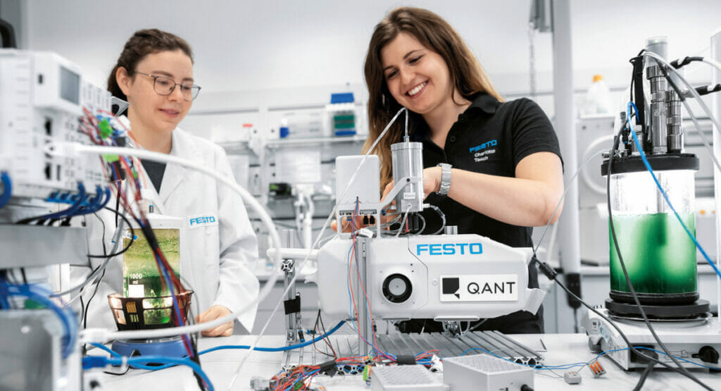 Bild von einem Labor, in dem zwei Frauen an Maschinen arbeiten.