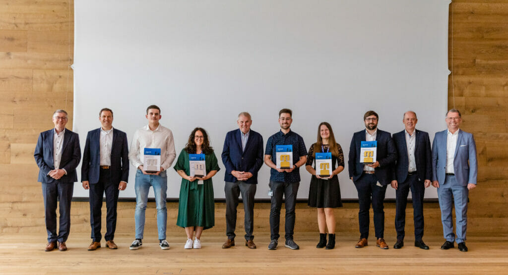 Bild von Personen, die auf einer Bühne bei einer Preisverleihung stehen