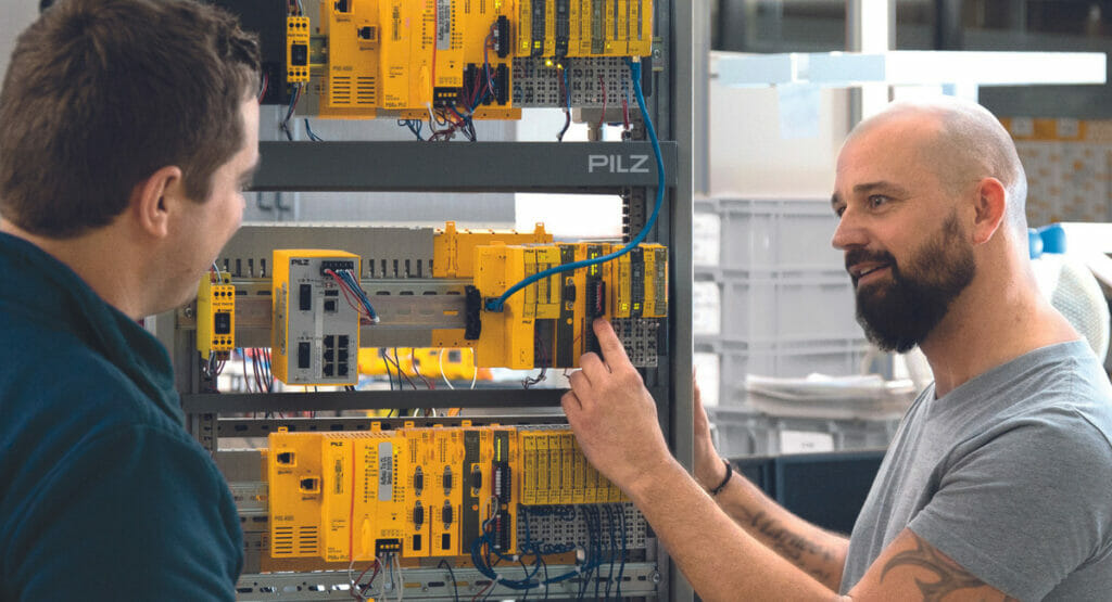 Bild von zwei Männern an einer Automatisierungsmaschine