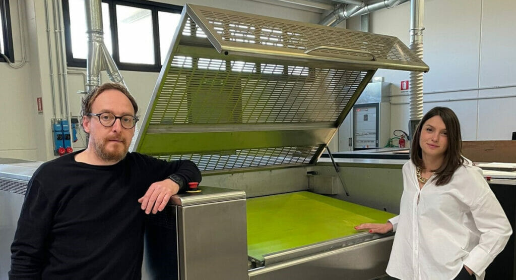 Bild von einem Mann und einer Frau, die vor einer Druckmaschine stehen