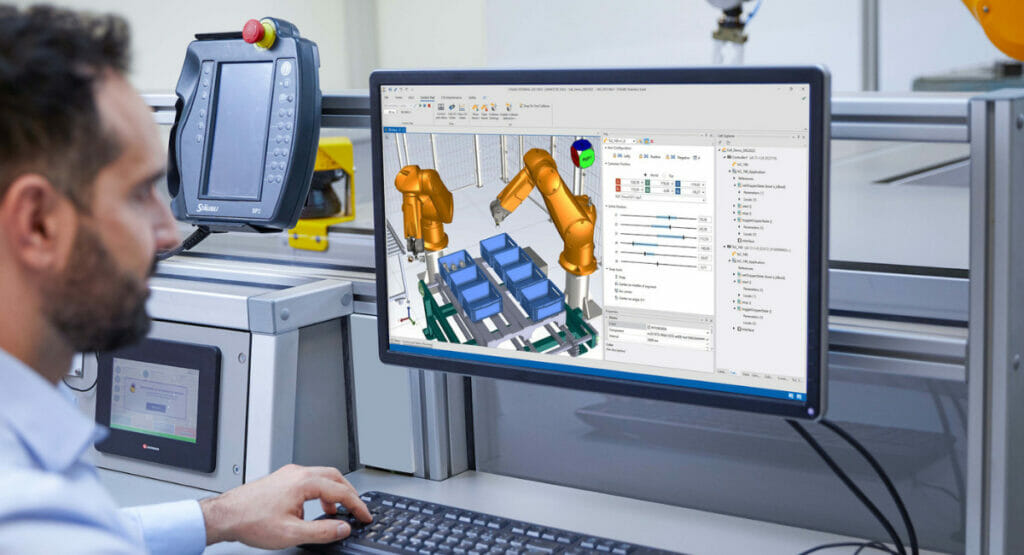 Bild von einem Mann, der na einem Computer arbeitet, der eine Maschine kontrolliert.