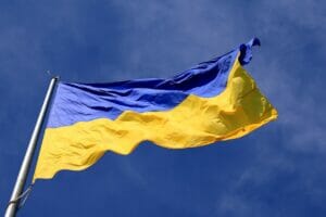 Bild von der Flagge der Ukraine, im Wind wehend, vor blauem Himmel