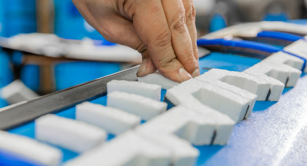 Bild von einer Hand, die an einem Stanzwerkzeug arbeitet.