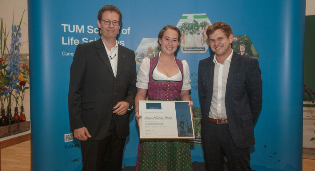 Bild von zwei Männern und einer Frau bei einer Preisverleihung