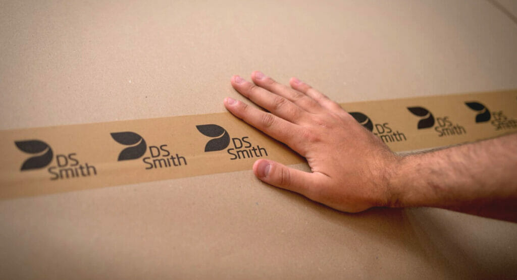 Bild von einer Hand, die über eine Klebeband auf einer Versandverpackung fährt