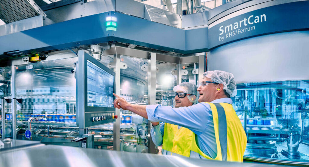 Picture of two men in protective clothing standing at a bottling line