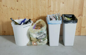 Bild von unterschiedlichen Abfallbehältern vor einer Wand