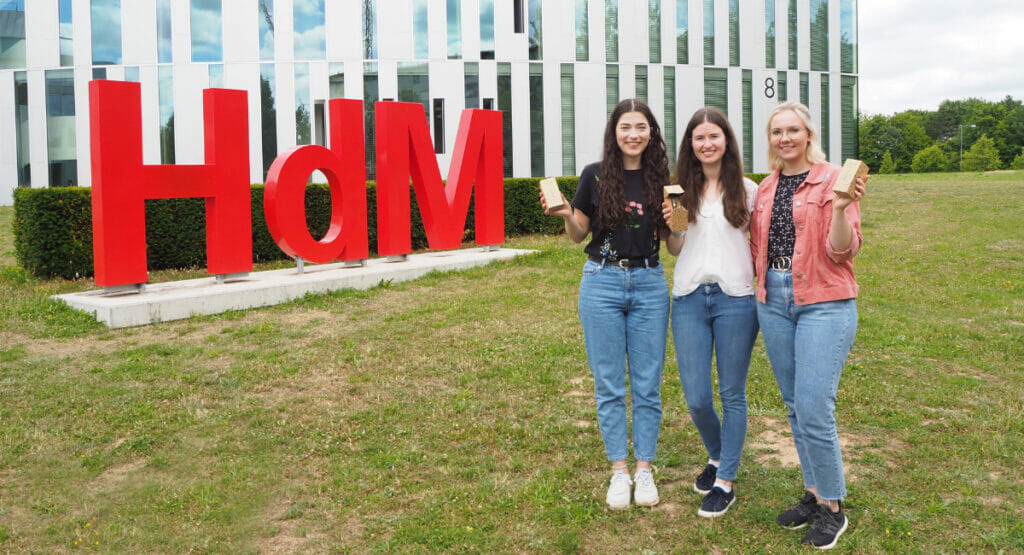 Image of three women standing in front of a university building