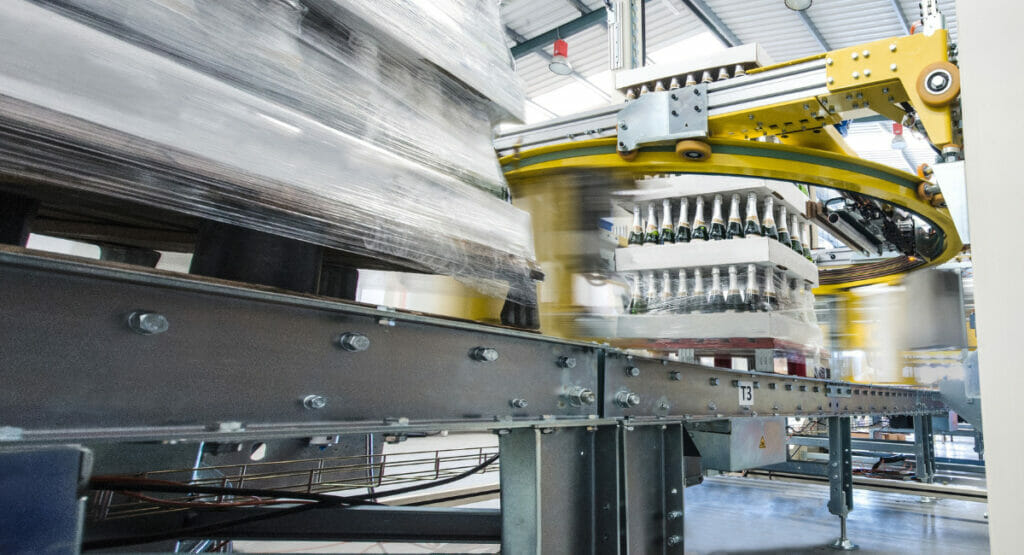 Bild von einer Umreifungsmaschine und einem Stretcher, die Paletten mit Flaschen umwicklen