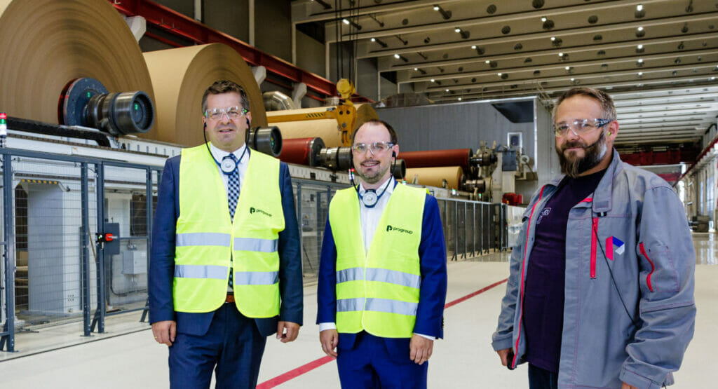 Bild von drei Männern bei der Besichtigung einer Papierfabrik