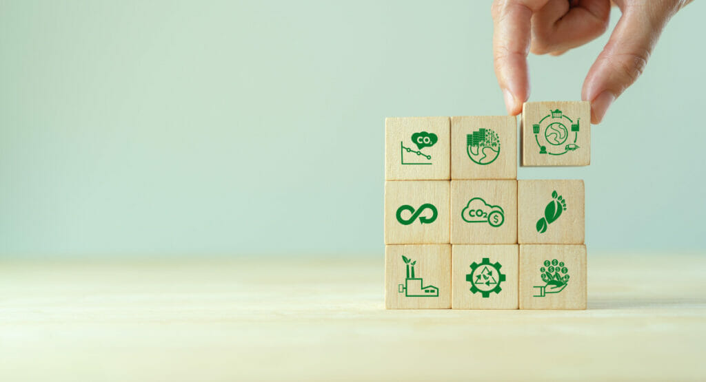 Bild von einer Hand, die Holzwürfel mit Symbolen aufeinander setzt