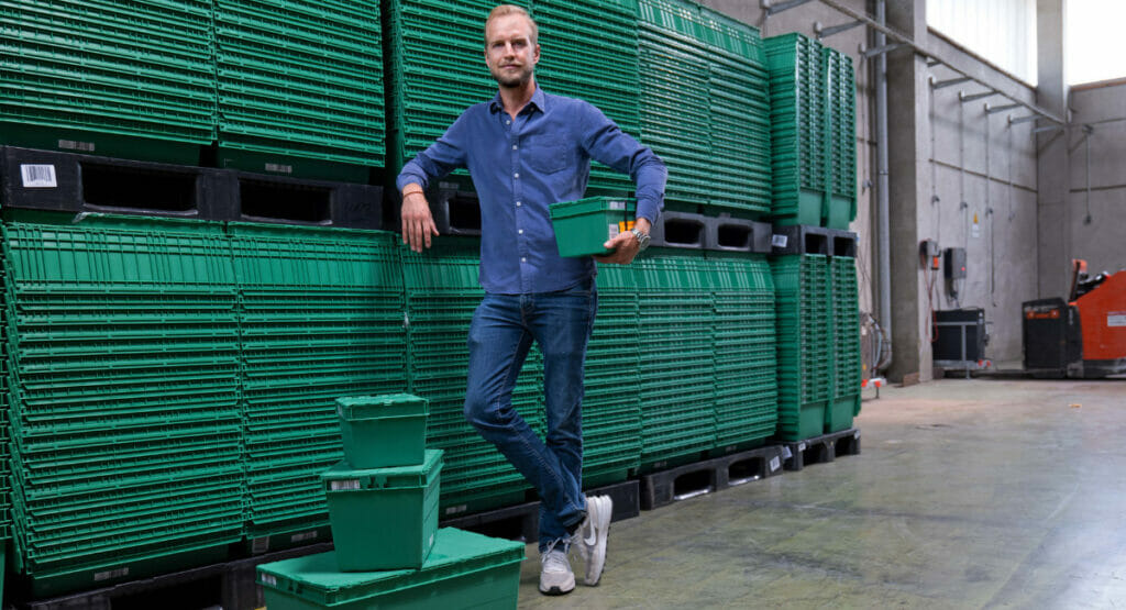 Bild von einem Mann, der an gestapelten Behältern steht